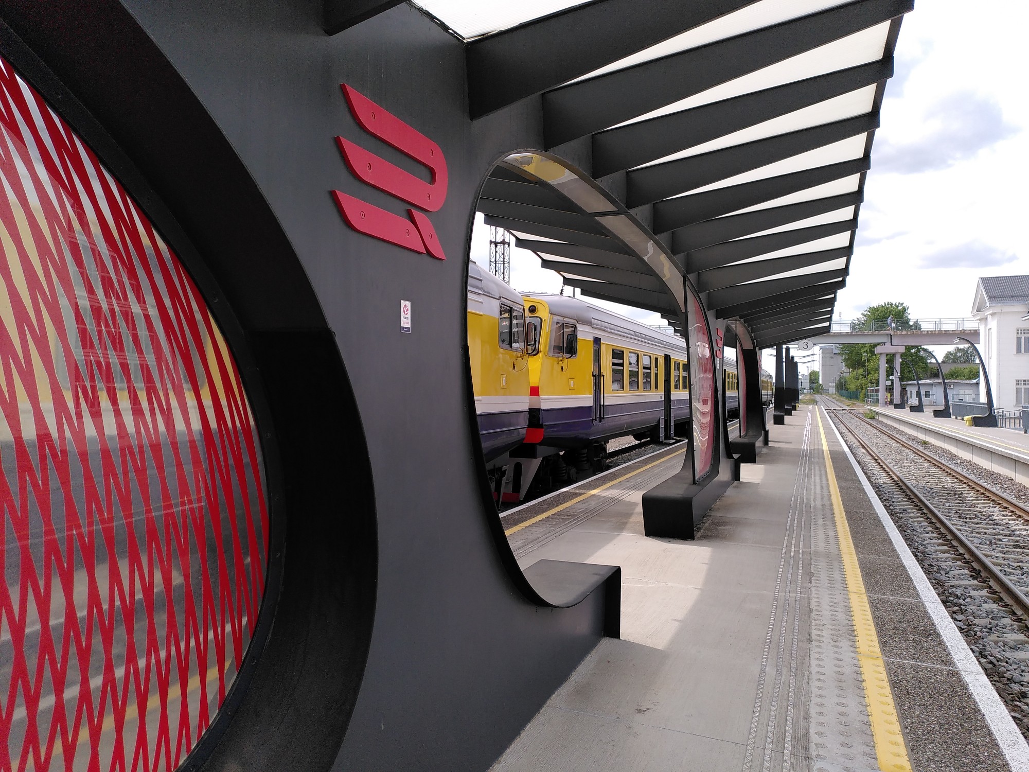 Picture of a Latvian train behind Estonian station furniture